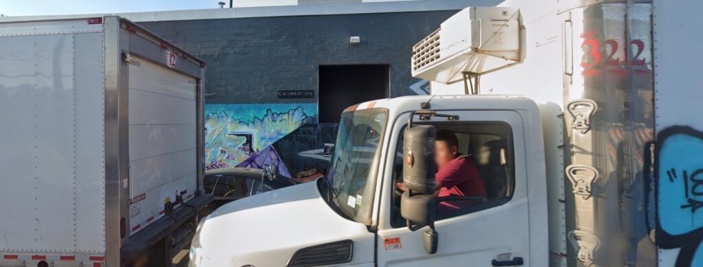 Photo of large moving truck in front of Bushwick building with graffiti